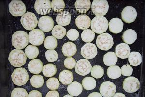 Очистить от кожуры 3 баклажана и нарезать тонкими кружками. Выложить на противень, слегка присыпать солью (по вкусу) и запекать до румяности при 230°C (около 5-7 минут).