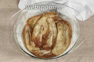 Разъёмную форму для выпечки (диаметром 24-26 см) смазать сливочным маслом, присыпать сахарным песком. Внахлёст выложить отваренные в сиропе баклажанные пластинки. Если предполагаете, что пластинок вышло много, то можно в 2 слоя, но не больше 3.