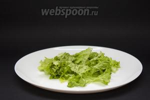 1 пучок салата режем на кусочки или рвём руками. На дно 2 тарелок выкладываем по половине пучка измельчённых салатных листьев.