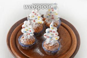 Готовые охлаждённые маффины украсить по своему желанию. Например, можно посыпать их сверху сахарной пудрой и украсить декором-ёлочкой.