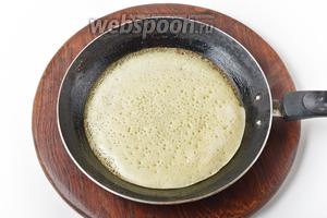 Выпечь блинчики, порционно выливая тесто на хорошо разогретую сковороду.