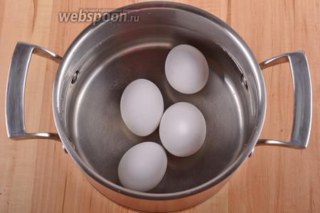 Пока варится филе, выложить 4 яйца в кастрюлю с 1 литром холодной воды. Довести воду до кипения. Снять с огня, а яйца оставить в воде на 6 минут, а затем переложить их в посуду с ледяной водой и очистить.