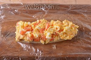 На пищевую плёнку выложить 1 филе солёной сельди, без шкурки и костей, кожей вниз. Сверху выложить начинку.