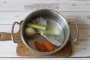 Мясо переложить в кастрюлю, заполнить её чистой питьевой водой (2 литра), довести до кипения. Как только вода закипит, убавить огонь, добавить в кастрюлю овощи: репчатый лук, стебли сельдерея и морковь.